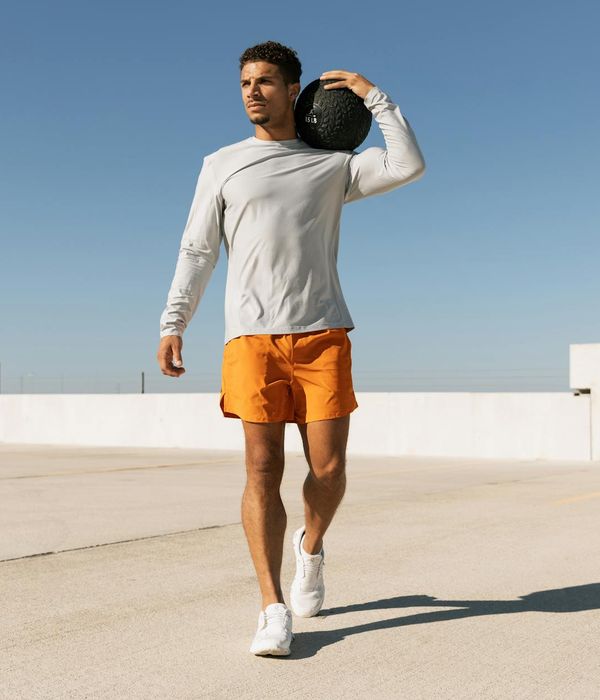Man performing a powerful strength exercise in a modern gym.